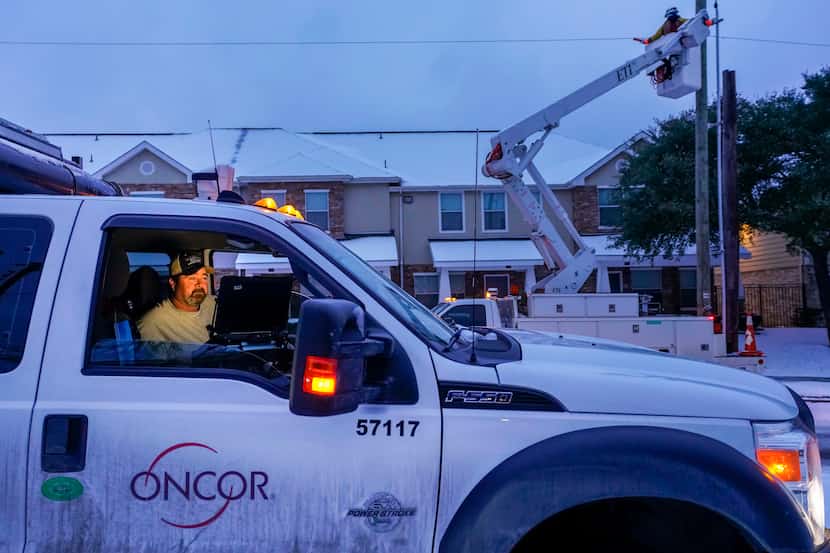 An Oncor crew works on along Elsie Faye Heggins Street as power outages continue across the...