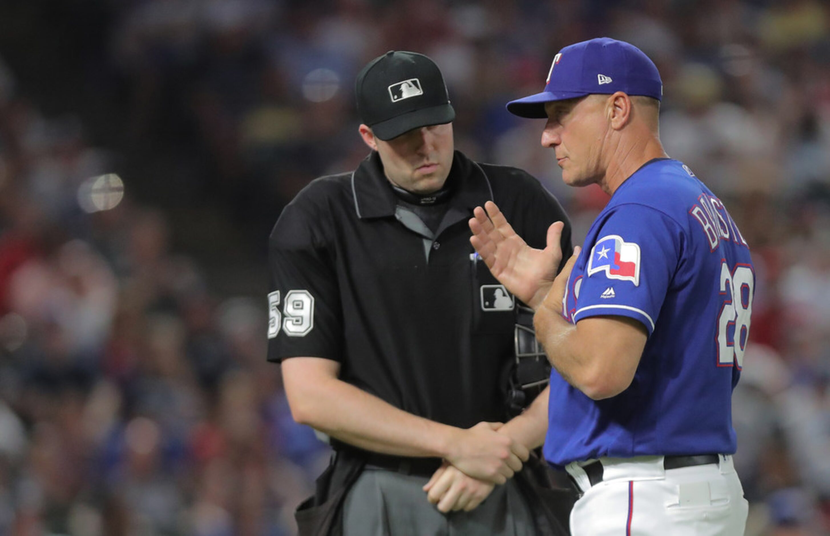 Texas Rangers manager Jeff Banister (28) challenges a hit by pitch call by home plate umpire...