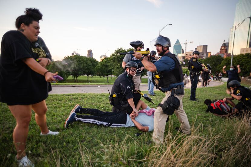 Dallas police Sgt. Roger Rudloff fires pepper balls at a protester (left) standing only a...