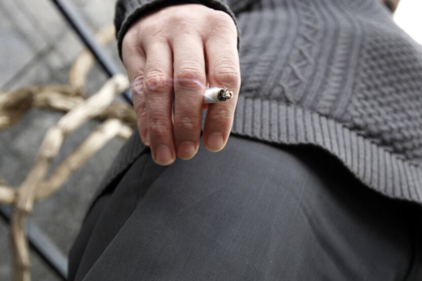 Nathan Morgan smokes a cigarette during a break from work outside Renaissance Tower in...
