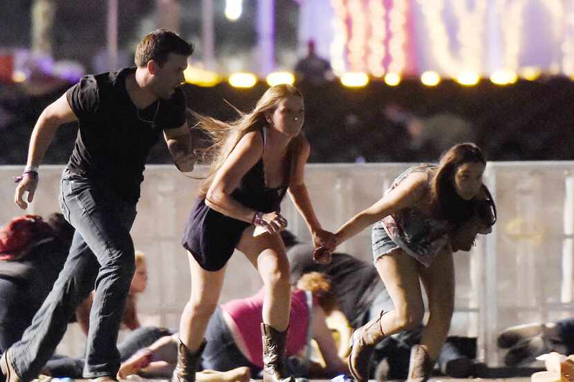 People run from the Route 91 Harvest country music festival after apparent gun fire was...