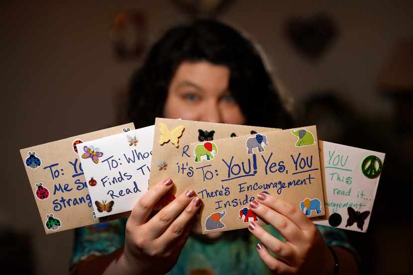 Angela Joy Bailey poses for a photograph with the cards she wrote at her grandparents' home....