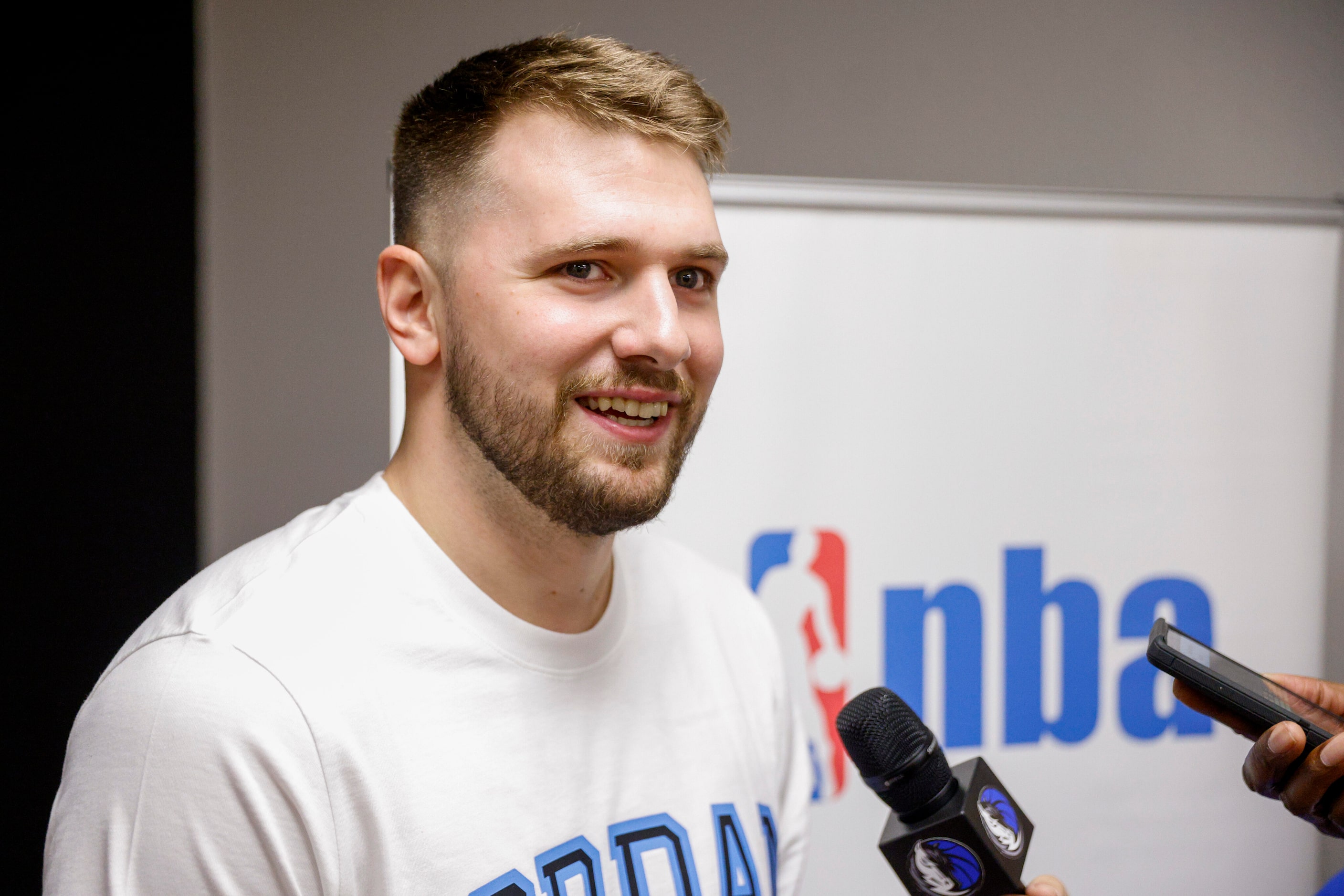 Dallas Mavericks guard Luka Doncic speaks with members of the media after a children’s...