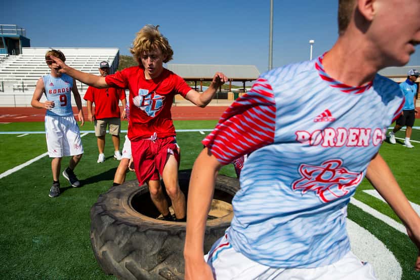 Borden County High School junior Ethan Stephens jumps through a tire during football...