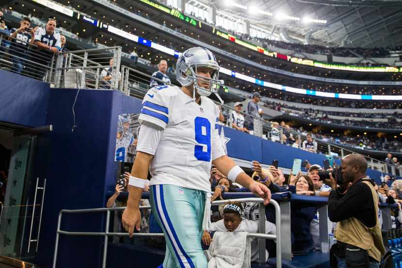 Dallas Cowboys quarterback Tony Romo (9) walks on the field to warm up before their game...