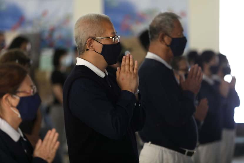 Members of the Tzu Chi foundation say a prayer at the Tzu Chi foundation in Richardson, TX,...