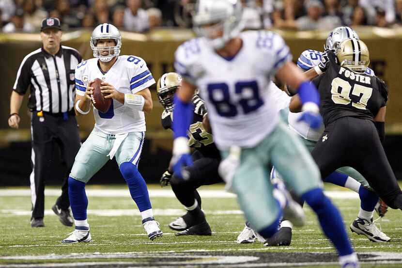Dallas Cowboys quarterback Tony Romo (9) looks toward Jason Witten's direction as he drops...