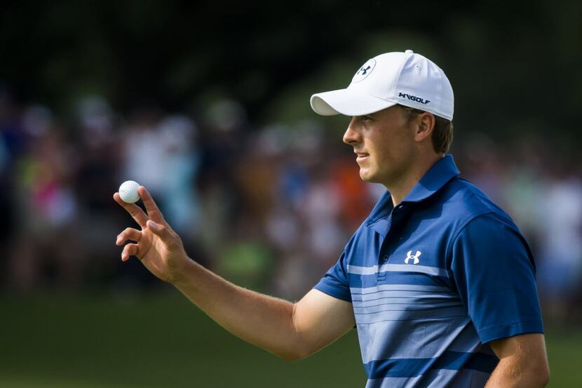 Jordan Spieth acknowledges the gallery after sinking a birdie put on the 18th green during...