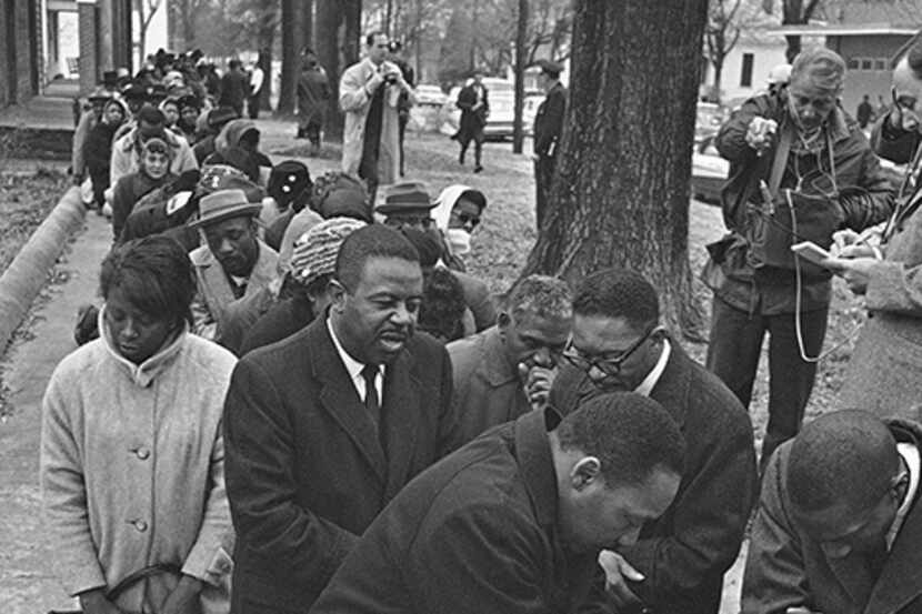The Rev. Martin Luther King Jr. leads a group of civil rights workers in prayer on Feb. 1,...