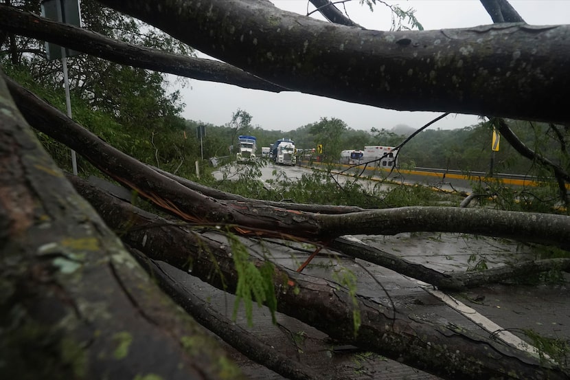 Camiones parados en una carretera bloqueada por un deslizamiento de tierra provocado por el...