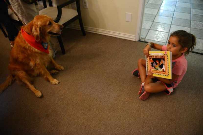 
Arianna Crump, 6, reads When the Rooster Crowed to therapy dog Faith at The Samaritan Inn....