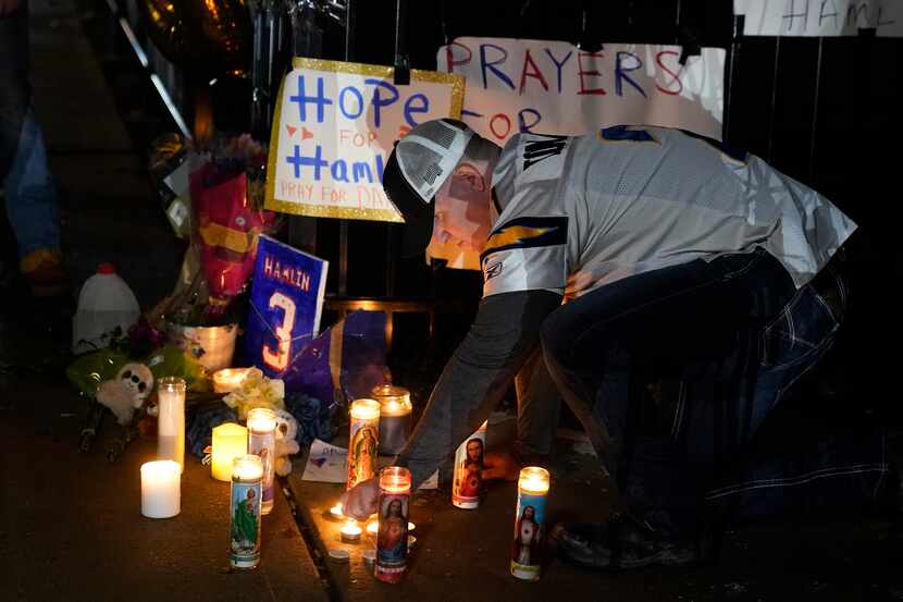 Brandon Metzger lights candles before a prayer vigil for Buffalo Bills' Damar Hamlin outside...
