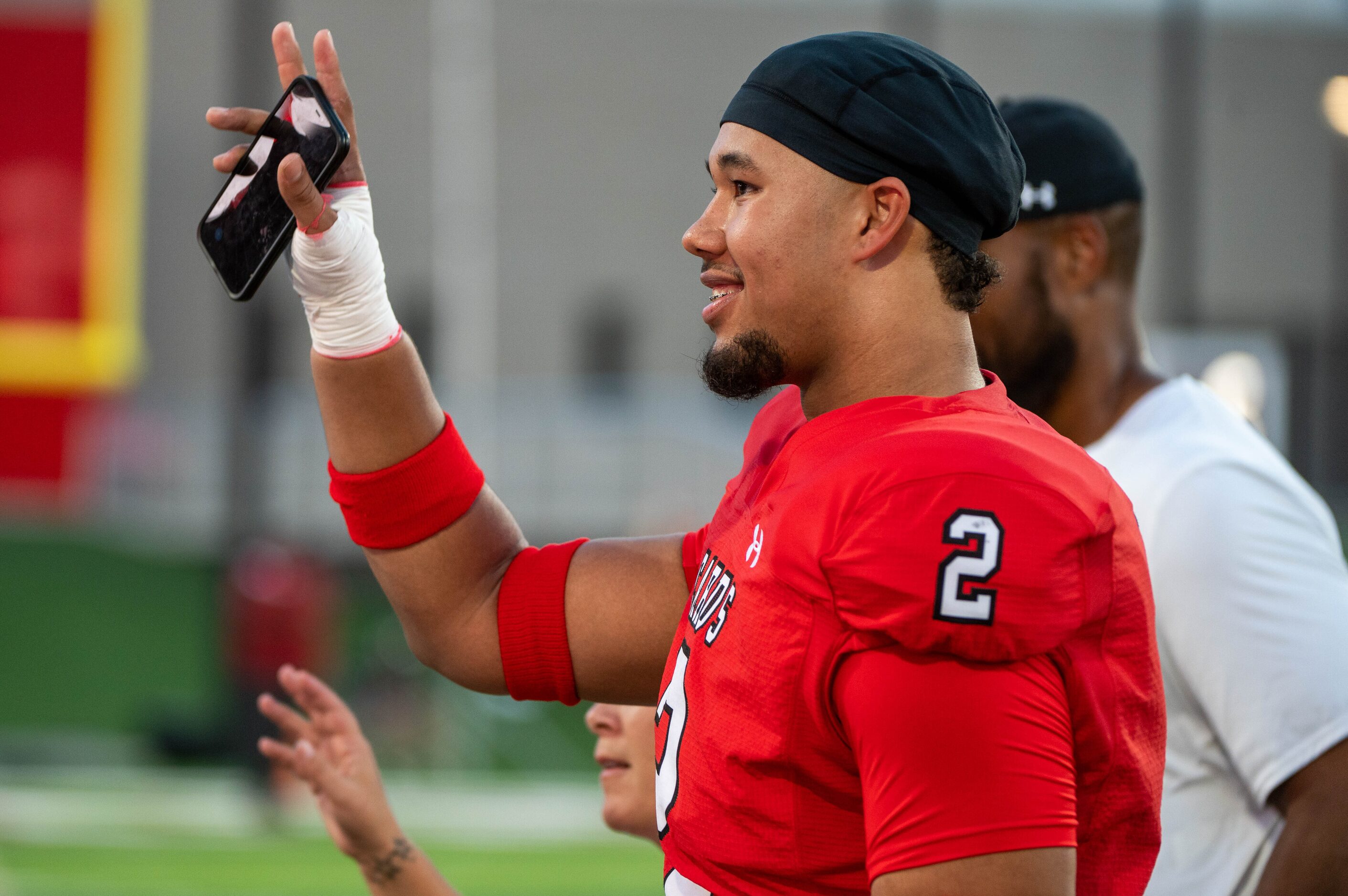 Melissa defensive end Nigel Smith (2) waves to the crowd after he made his college choice,...