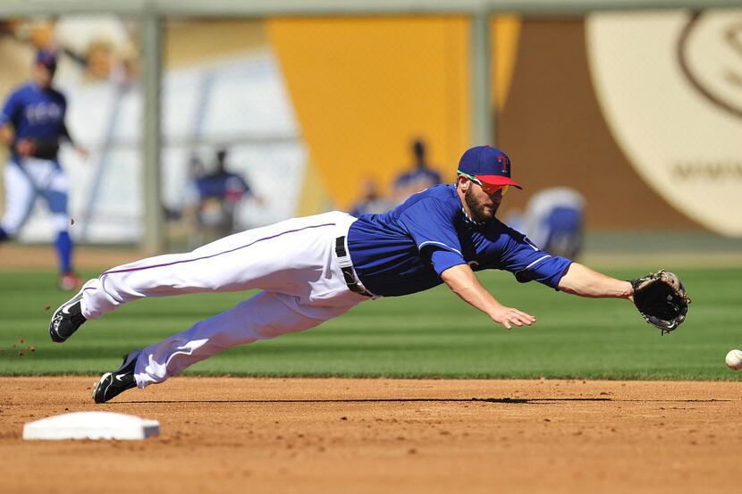 March 8, 2014; Surprise, AZ, USA; Texas Rangers shortstop Josh Wilson (12) misses catching a...