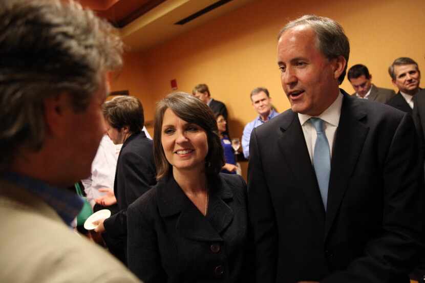 Ken Paxton (center) celebrates with his wife, Angela Paxton, after a guest announced he won...