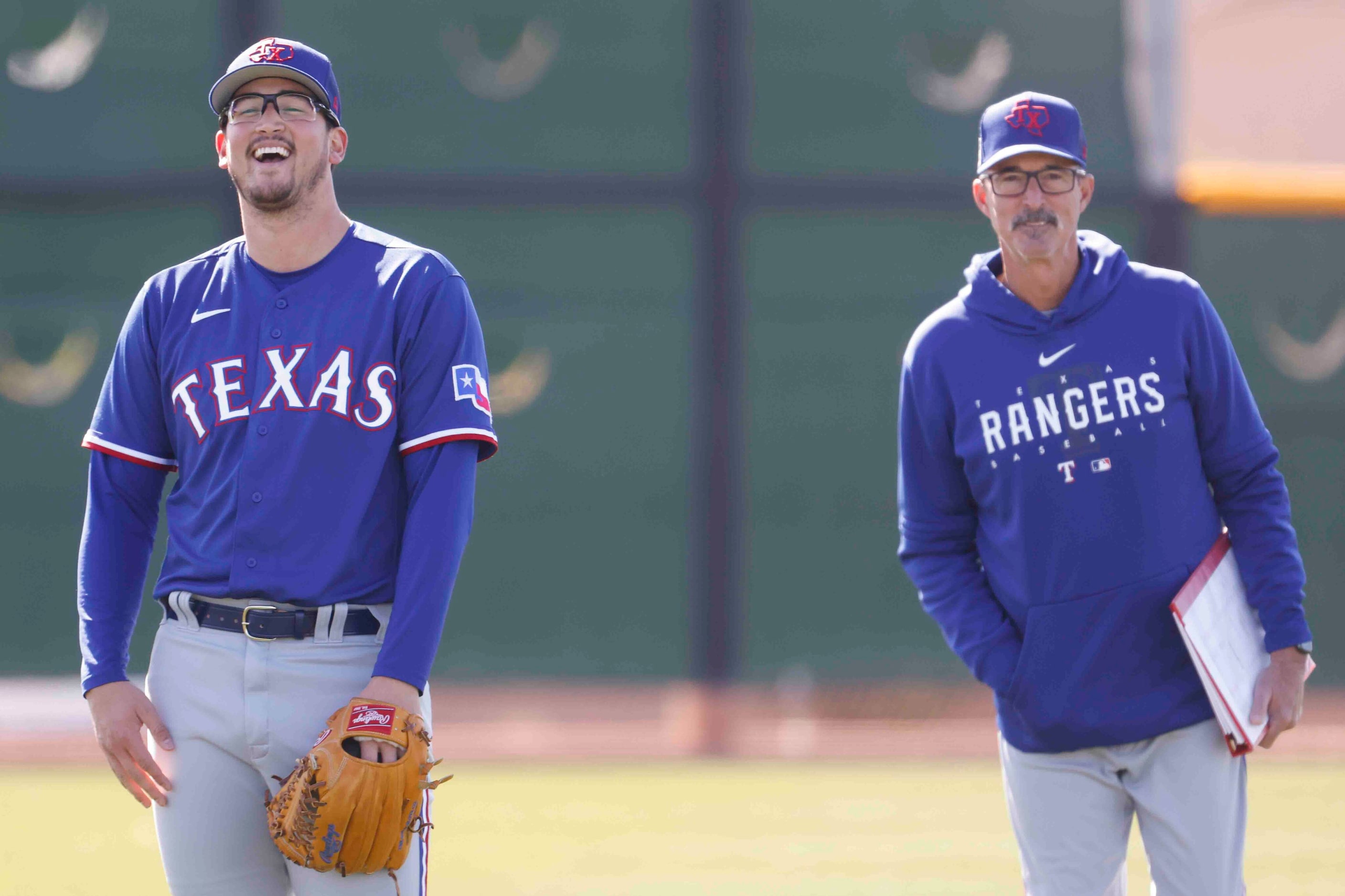 Texas Rangers right handed pitcher Dane Dunning, left, and pitching coach Mike Maddux laugh...