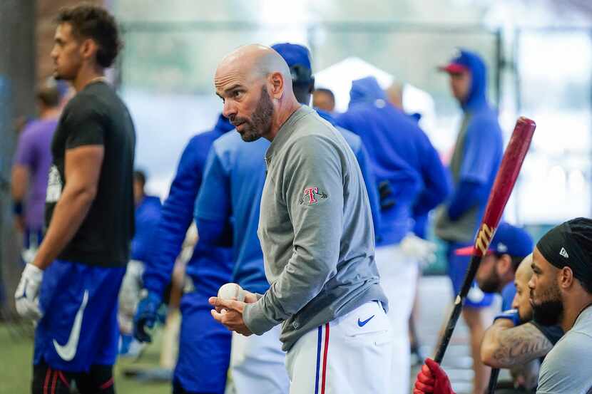 FILE - Rangers manager Chris Woodward works hitters in the indoor batting cage during a...