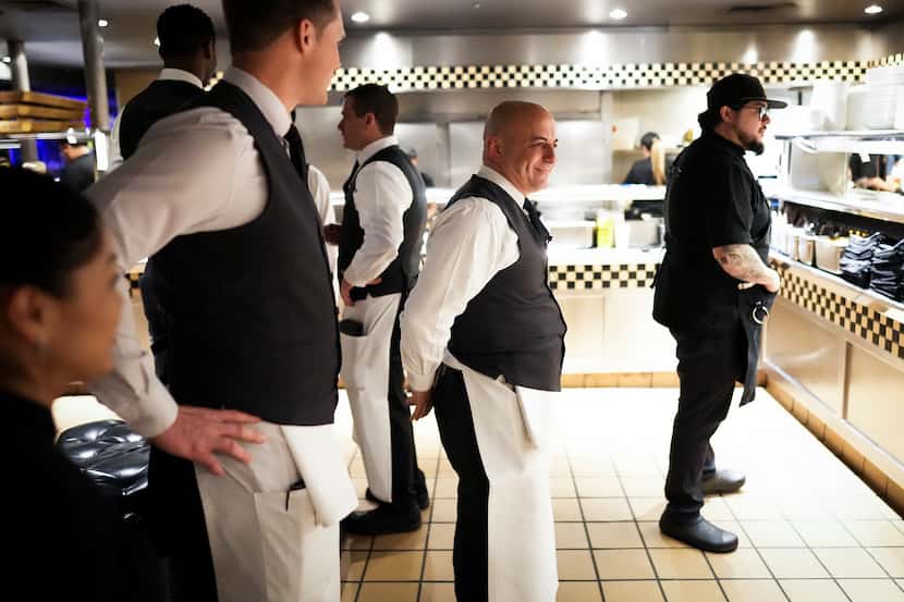 Server Benny Bajrami (center) waits with other staff for an order to come out of the kitchen...