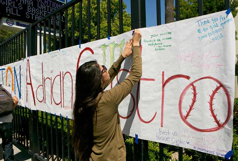 An El Monte High School student hangs a banner for senior Adrian Castro, who was killed when...