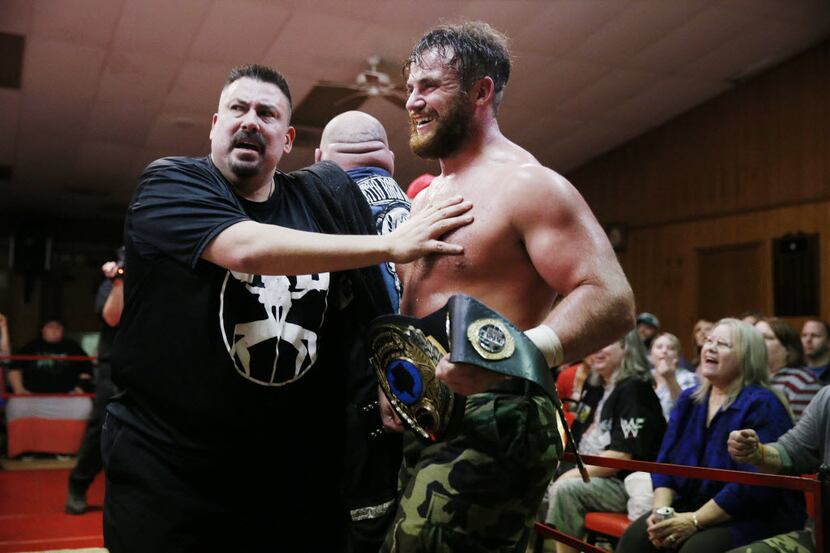 Professional wrestler Moonshine Mantell (right), whose real name is Ryan Greeness, is held...