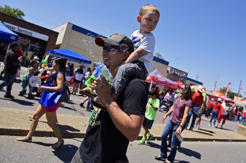 Andrew Rodríguez lleva a su hijo Drew, por la Jefferson Boulevard, Oak Cliff, durante las...