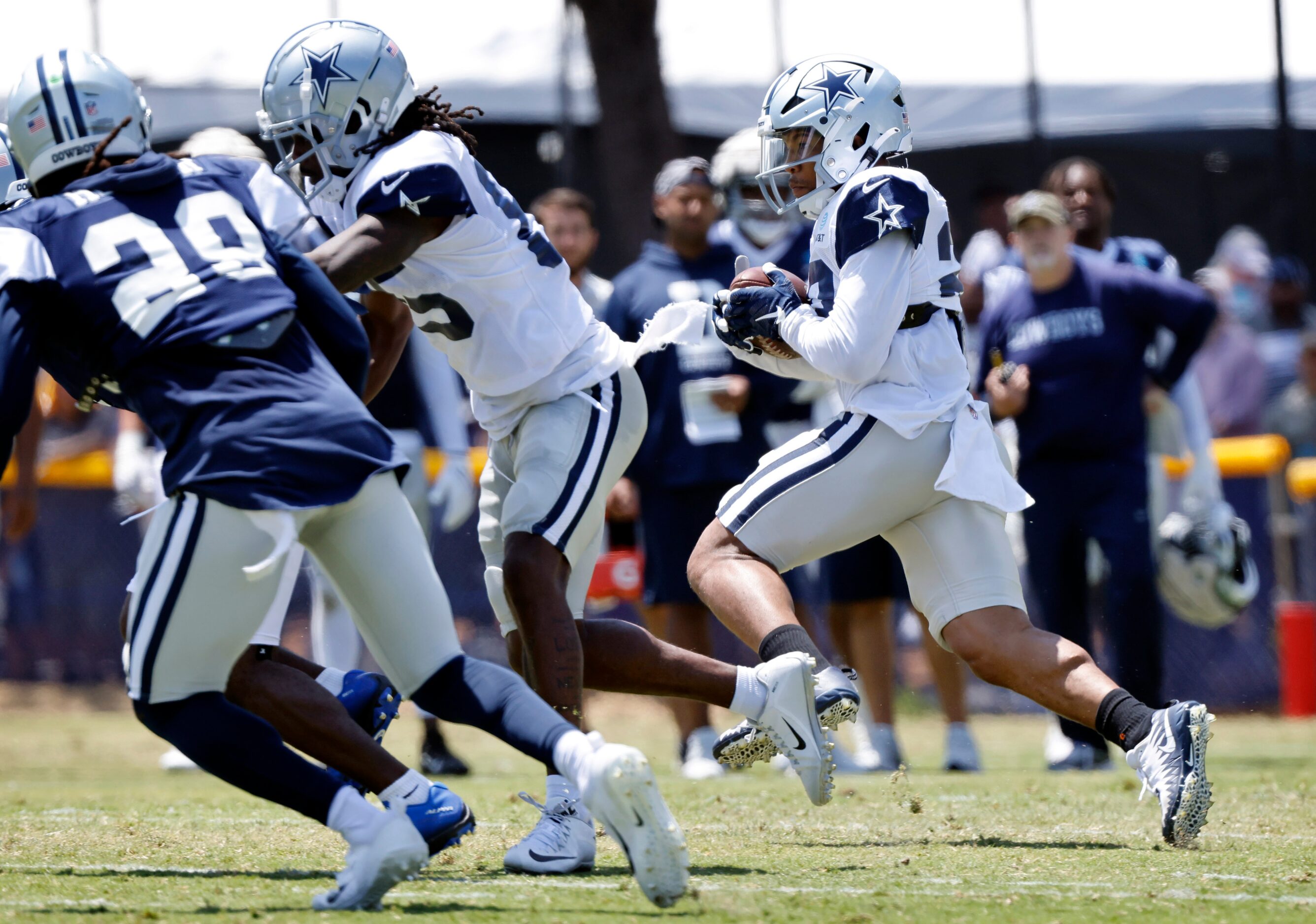 Dallas Cowboys running back Tony Pollard (20) follows his blockers as he sweeps to the...