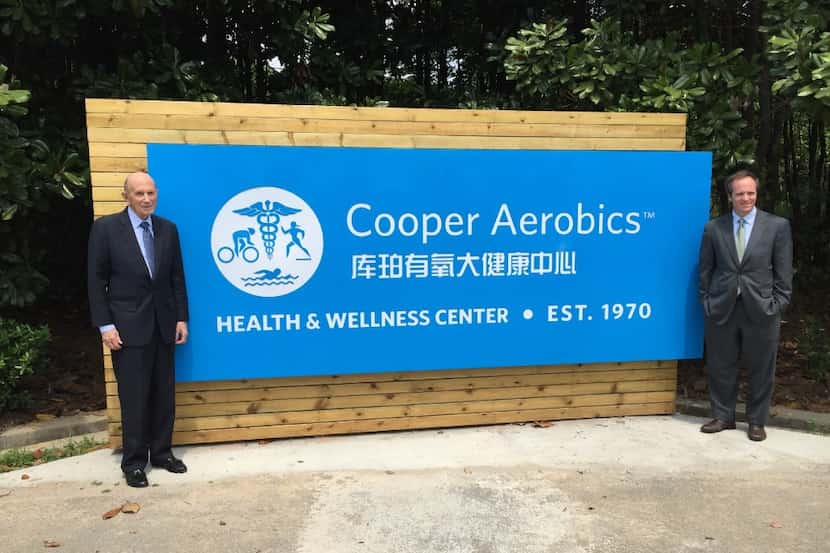 Ken Cooper and his son Tyler Cooper pose with a sign at Cooper Aerobics Health and Wellness...