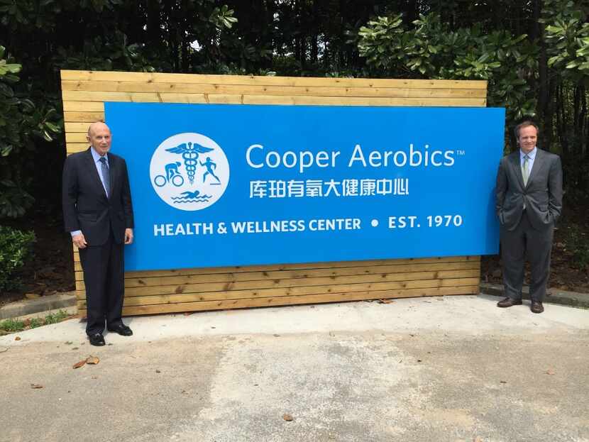 Ken Cooper and his son Tyler Cooper pose with a sign at Cooper Aerobics Health and Wellness...