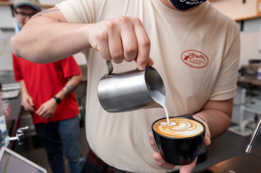 Noah Irby pours milk into a cappuccino at Wayward Coffee, the shop he opened with Trevin...