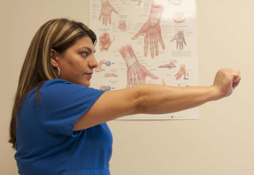 Brenda Alvarez demonstrates Step 7 of an arm exercise to alleviate hand pain.