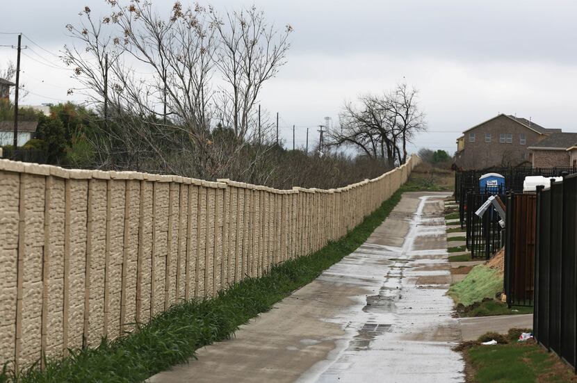 A fence lines the alley separating the University Place subdivision from the easement for...