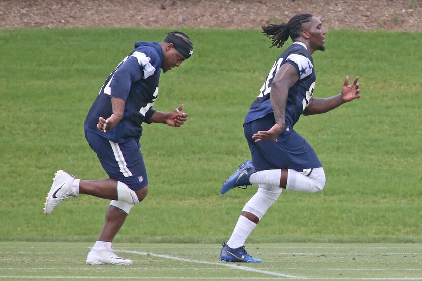 Dallas Cowboys defensive ends Demarcus Lawrence (90), right, and Kony Ealy (76) run during a...