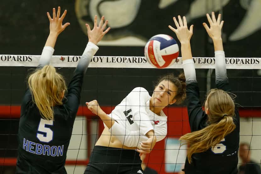 Lovejoy's Hannah Gonzalez (12) spikes the ball between Hebron's Hannah Redrow (5) and Sophie...