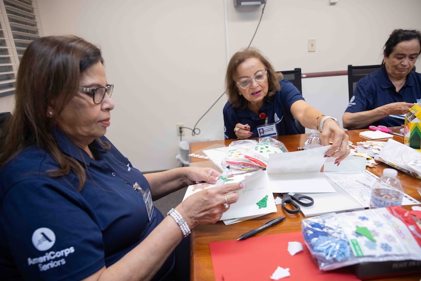 (From left) Yasmeen Ali, Habiba Merchant and Fatima Patel decorate holiday card as...