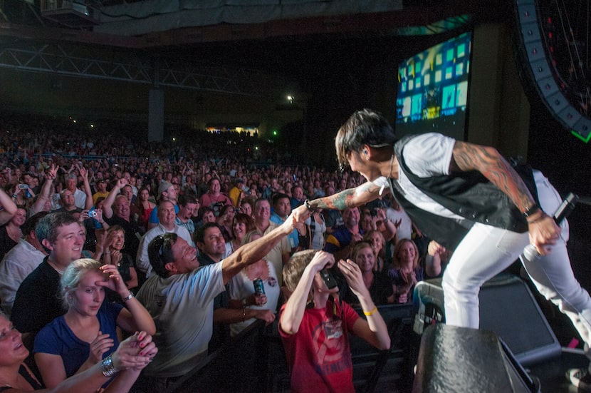 Arnel Pineda, the lead singer of Journey engages the fans as he performs at the Gexa Energy...