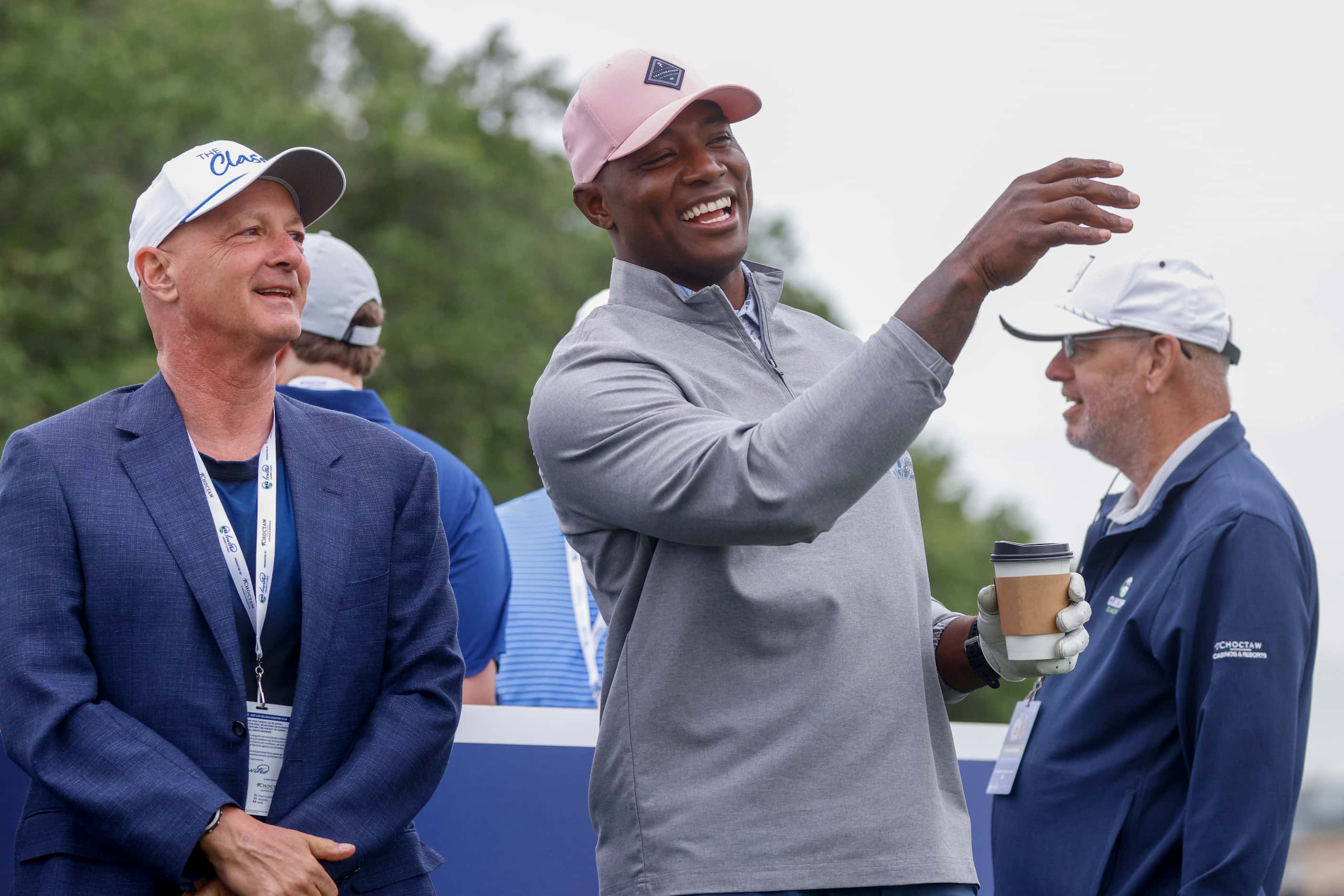 Former Dallas Cowboys player DeMarcus Ware laughs with a course official before the first...
