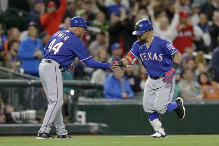 Texas Rangers' Rougned Odor is congratulated by third base coach Spike Owen after hitting a...