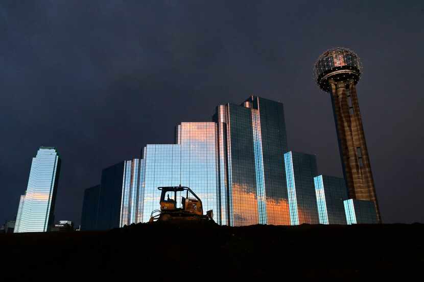 A sunset reflects off the Hyatt Regency Dallas and Bank of America Plaza downtown. (Tom...