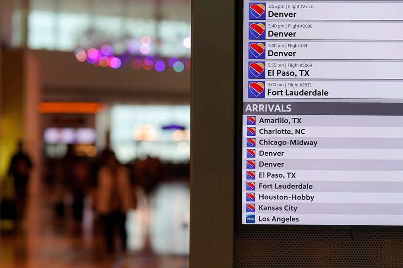 A flight status display show Southwest Airlines arrivals and departures at Dallas Love Field...