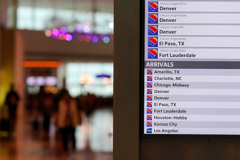 A flight status display show Southwest Airlines arrivals and departures at Dallas Love Field...