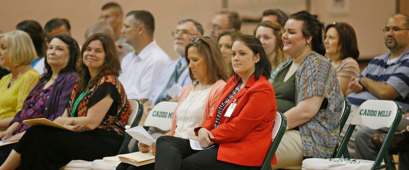 
Principal Jana Everett (in red jacket) sits among school teachers and administrators at the...