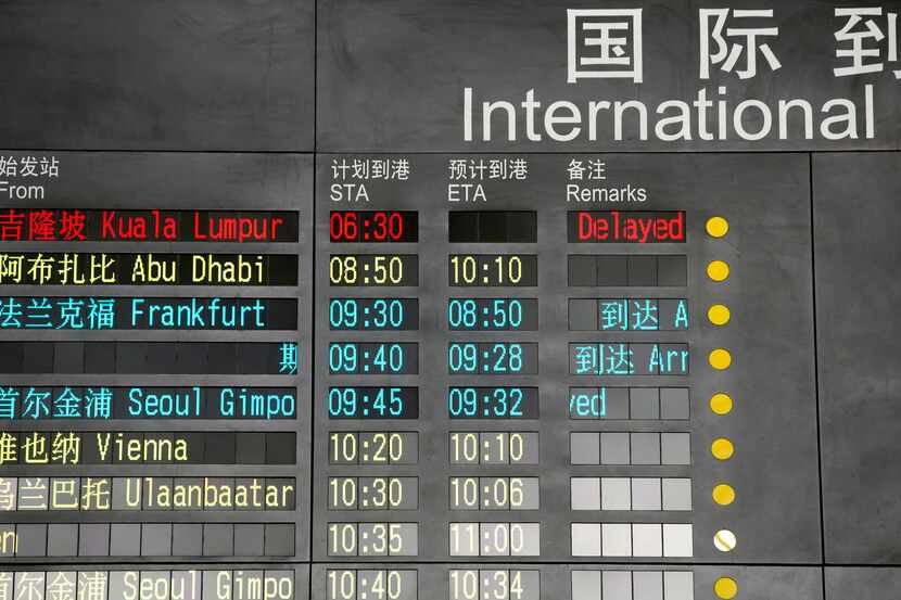 The arrival board at the International Airport in Beijing shows a Malaysian airliner is...
