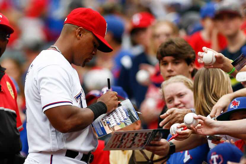 Texas Rangers' Adrian Beltre gives autographs to fans before his team's baseball game...