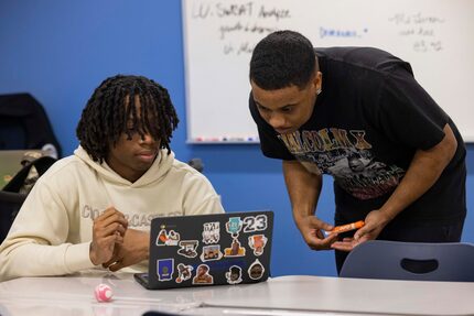 Teacher Joshua Castille talks to senior Kenneth Haggerty, 18, as he reads “The Autobiography...