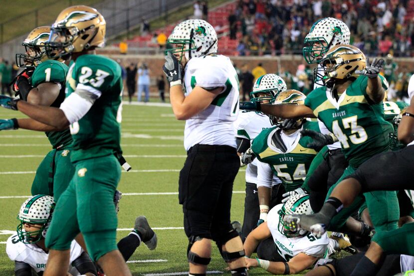 Southlake High QB Kenny Hill (far left) lies on the ground with the ball, as DeSoto High...