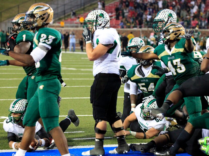 Southlake High QB Kenny Hill (far left) lies on the ground with the ball, as DeSoto High...