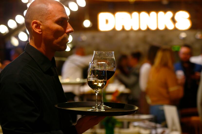 Valerio Dujmovic serves wine at a remodeled and reopened Cafe Express on McKinney Avenue in...