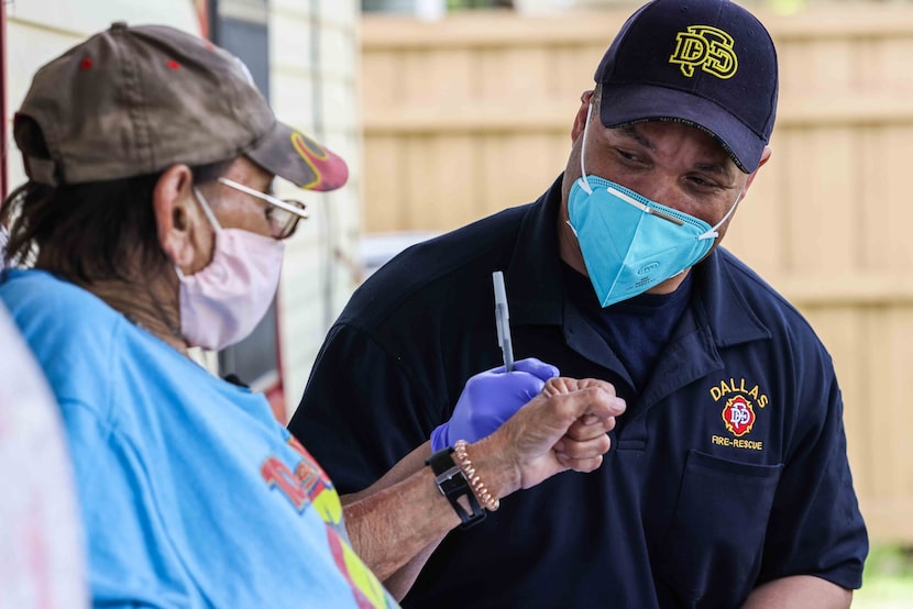 Dallas Fire-Rescue medic Corey Nix gives a fist bump to Albert Garza, after Garza received...