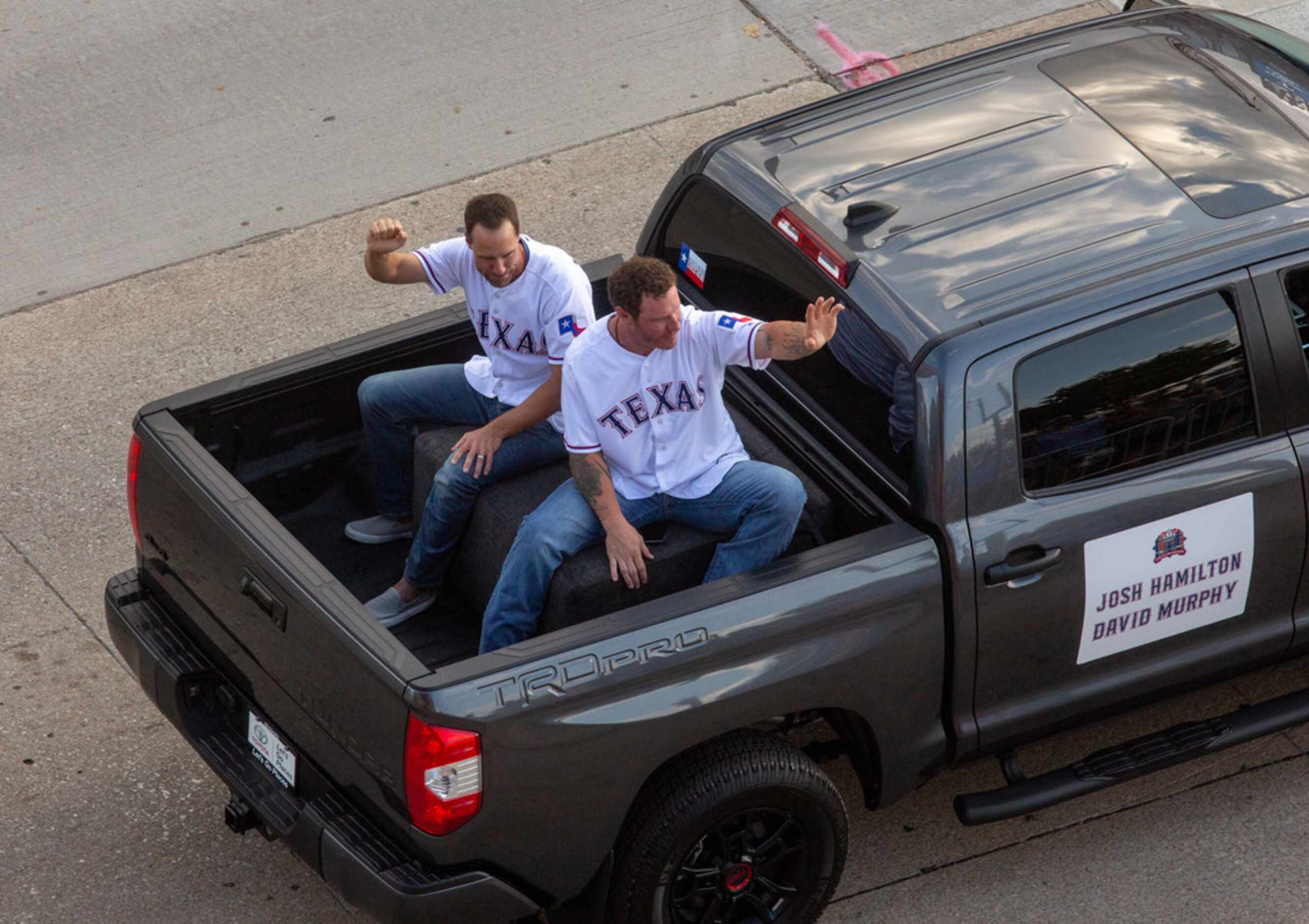 Former Texas Rangers Josh Hamilton and David Murphy ride on a Toyota truck during a parade...