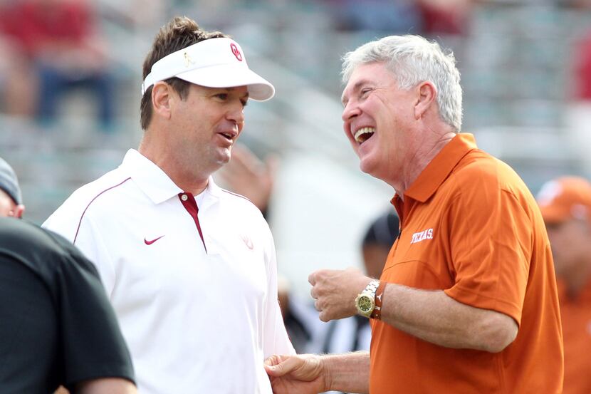 Oklahoma Sooners head coach Bob Stoops talks with Texas Longhorns head coach Mack Brown...